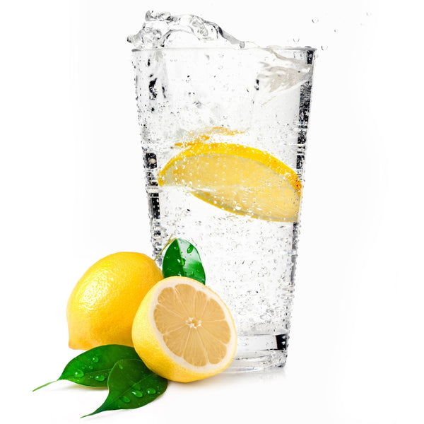 A glass of Lemon Hard Seltzer with a lemon wedge next to it.