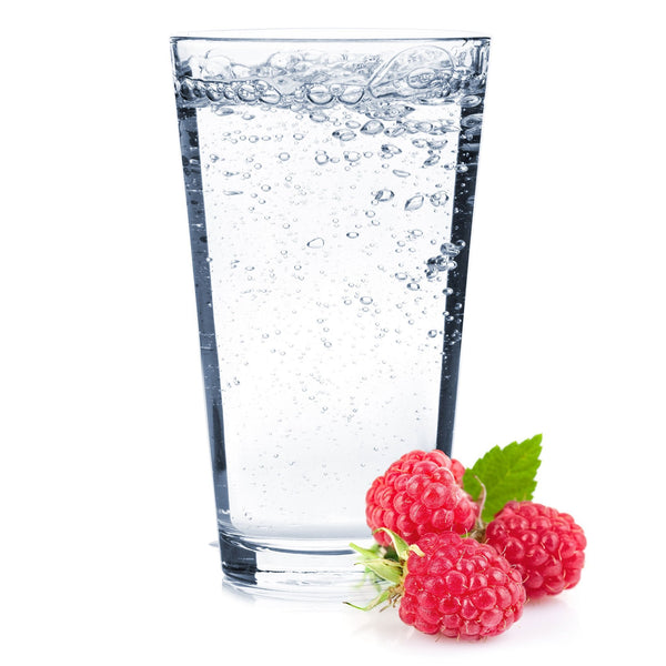 A glass of Raspberry Hard Seltzer with fresh raspberries next to it.