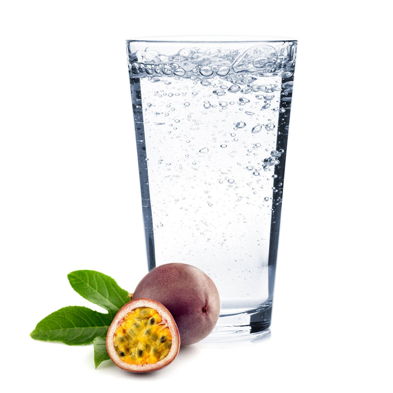 A glass of Passionfruit Hard Seltzer with a halved passionfruit next to it.